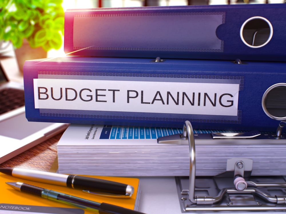 Blue Ring Binder with Inscription Budget Planning on Background of Working Table with Office Supplies and Laptop. Budget Planning Business Concept on Blurred Background. 3D Render. Blue Ring Binder with Inscription Budget Planning on Background of Working Table with Office Supplies and Laptop. Budget Planning Business Concept on Blurred Background. 3D Render.